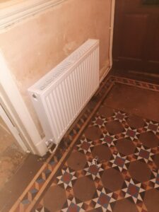 a white radiator on a tiled floor