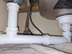 a white pipes under a sink