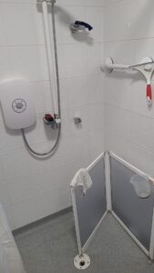 a shower with a white shower and a white towel